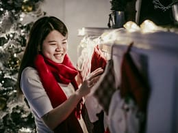 Woman hanging Christmas stocking over firepla.width .jpg