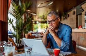a person wearing glasses looking at laptop.jpg