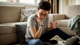person sitting on floor looking at documents