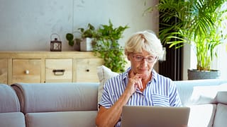 senior woman holding laptop gettyimages