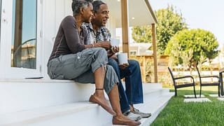smiling couple sitting on a porch