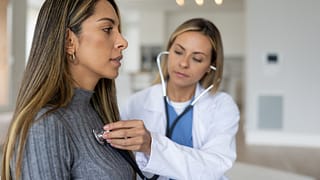 a doctor placing a stethoscope on a persons chest gettyimages