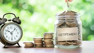 retirement savings jar full of coins and alarm clock