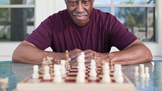 older man playing chess strategy moves winning