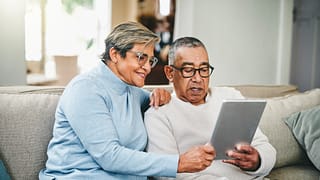 senior couple using a digital tablet at home QWPBm