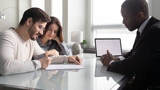 Couple signing paperwork with an agent ooiUfy.width