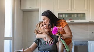 Daughter gives flowers and a hug to mother vm.width .jpg