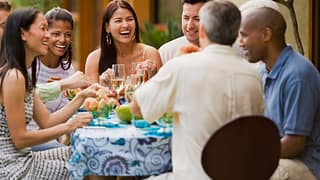 Group of friends dining on restaurant patio t.width