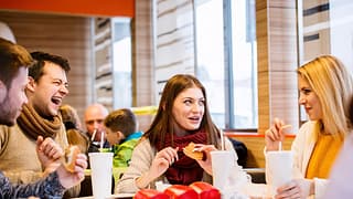 Group of friends eating fast food burgers and.width .jpg