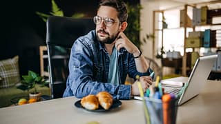 Man using laptop looks away appearing to be i.width mpyFQA