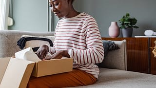 Woman packing up box to return item. juBzvHy.width
