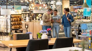 couple with saleswoman in furniture store Ztc.width .jpg