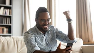 happy man with phone pumping fist dWwY.width