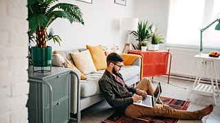 person on living room floor with laptop LRGGF.width .jpg