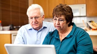 senior couple serious at laptop gettyimages
