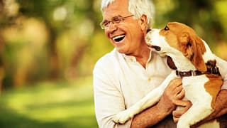 senior man smiling being licked by dog gettyimages .jpg