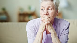 senior woman worried thinking with hands clasped in front of face.jpg