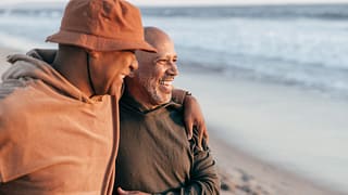 two people smiling hugging on the beach