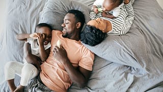 two parents with young kids on bed HxMda.width .jpg