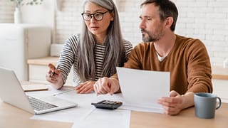 two people with bills and laptop hENMu.width .jpg