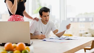 two worried people at kitchen table with bill.width MIUbkr