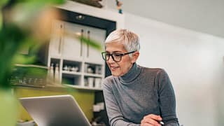 woman at home with laptop and paperwork iLty.width