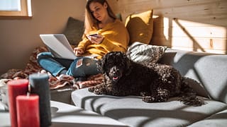 woman holding credit card with dog and laptop.width ECGu.jpg