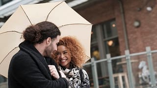 Couple walking through city under umbrella Ab.width .jpg