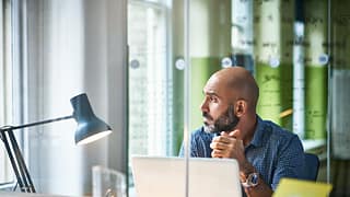 Mature man at desk looking off in thought ZmW.width .jpg