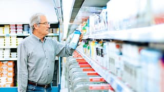 Mature man reads the label on a milk carton i.width .jpg