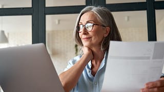 Mature woman working from laptop with documen.width ZiqNtKV.jpg