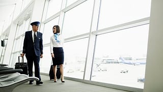 Pilot and flight attendant walking to airport.width LhaGV.jpg