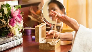Woman choosing necklace from jewelry box NAu.width .jpg