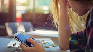 Woman holding smashed cell phone WAun.width .jpg