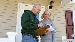 Woman on porch talking to man with clipboard .width .jpg