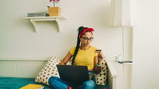 Woman relaxing at home looking at a credit ca.width cRZ.jpg