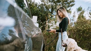 Woman with dog about to charge her electric c.width gkkvUm.jpg