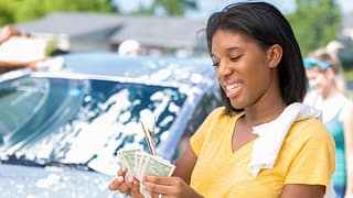 Young adult woman counts cash at car wash jbm.width .jpg