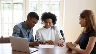 Young couple signing papers with an agent aq.width .jpg