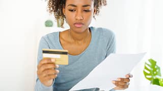 Young woman looking at credit card uQDfnW.width .jpg