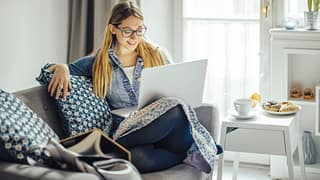 Young woman using laptop on the couch. KUYgdG.width .jpg