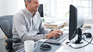 a smiling person at a computer gettyimages .jpg