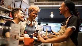 cafe employee with customers at counter Fzkr.width .jpg