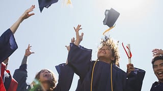 college graduates throwing mortarboards into .width mAUVTM.jpg