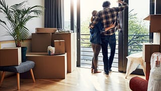 couple at window with moving boxes in new hom.width VeumdPo.jpg