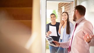 couple with realtor entering house cYeeLe.width .jpg