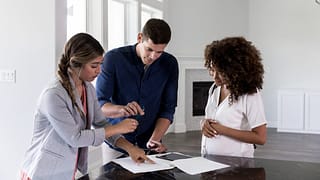 couple with realtor signing papers.width .jpg