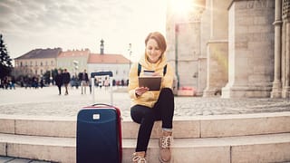 female traveler with suitcase tablet and cred.width sQbWMG.jpg