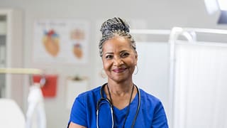 getty nurse smiling at camera with arms crossed healthcare.jpg