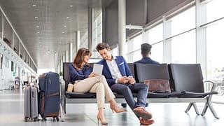 man and woman sitting at airport opGWJ.width .jpg